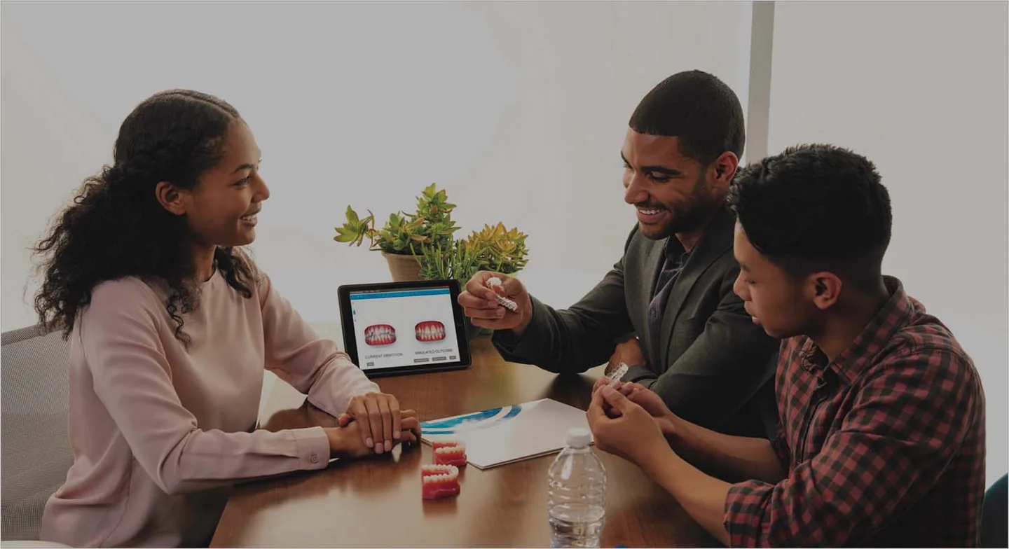 Orthodontist showing a patient her 3D treatment simulation and clear aligners